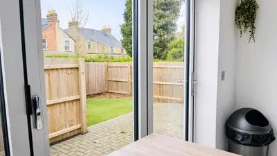 a door leading to a yard with a fence at Cambridge - Modern 4-BR Home with Gardens & Wi-Fi in Cambridge