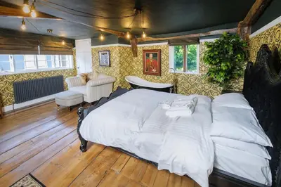 a bedroom with a large bed in a room at Luxury 2 Bed Manor House With Hot Tub, Cinema Room, Sky TV in Saffron Walden
