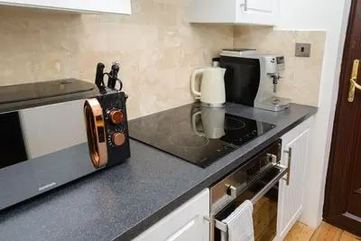 a kitchen with a microwave and a coffee maker on a counter at Deluxe 1 Bed Versace Hot Tub Sky TV Cinema Screen in Great Sampford