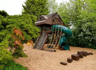 a playground with a small house and a slide at Deluxe 1 Bed Versace Hot Tub Sky TV Cinema Screen in Great Sampford