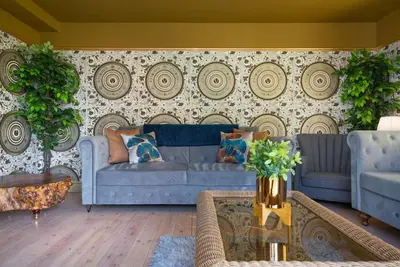 a living room with two blue couches in front of a wall at Deluxe 2 or 3 bed Cinema Games Room Pool Table Hot Tub in Great Sampford