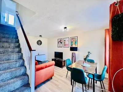 a living room with a staircase and a table and chairs at Hidden Gem in Chelmsford by Artisan Stays I Weekly or Monthly Stay Offer I Free Parking I Sleeps 5 in Chelmsford