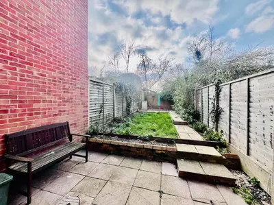 a bench sitting next to a brick building at Hidden Gem in Chelmsford by Artisan Stays I Weekly or Monthly Stay Offer I Free Parking I Sleeps 5 in Chelmsford