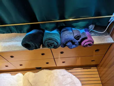 a pile of towels sitting on top of a bed at New Horizon - A beautiful boat very conveniently located in Chelmsford City in Chelmsford