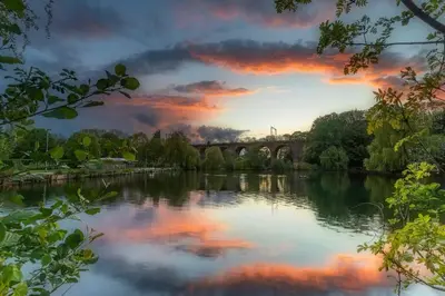 a bridge over a river with a sunset at New Horizon - A beautiful boat very conveniently located in Chelmsford City in Chelmsford