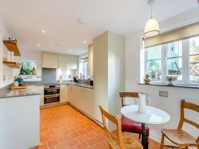 a kitchen with a table and chairs and a table at Malting Cottage in Much Hadham