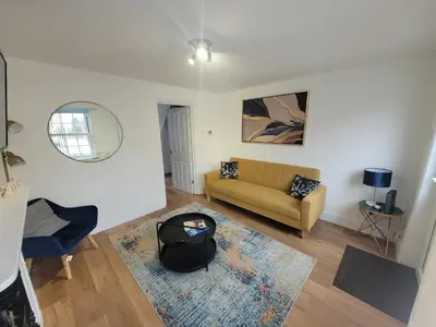 a living room with a couch and a mirror at Little Oaks House - Historic Charm & Modern Comfort in Colchester by Catchpole Stays in Colchester