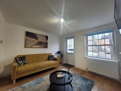 a living room with a couch and a window at Little Oaks House - Historic Charm & Modern Comfort in Colchester by Catchpole Stays in Colchester