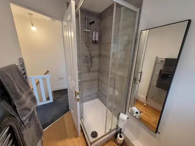 a shower with a glass door in a bathroom at Little Oaks House - Historic Charm & Modern Comfort in Colchester by Catchpole Stays in Colchester