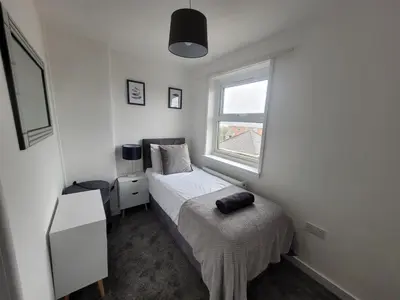 a small bedroom with a bed and a window at Little Oaks House - Historic Charm & Modern Comfort in Colchester by Catchpole Stays in Colchester