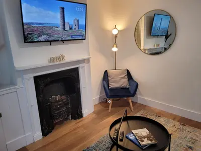 a living room with a fireplace and a tv on the wall at Little Oaks House - Historic Charm & Modern Comfort in Colchester by Catchpole Stays in Colchester