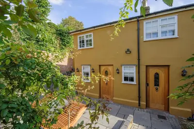 an exterior view of a yellow house at Executive Suite with Private Hot Tub SkyTV in Saffron Walden