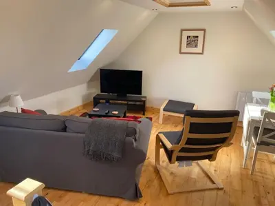 a living room with a couch and a tv at The Cartlodge, Debenham in Debenham