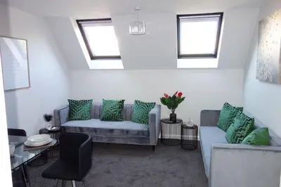 a living room with green pillows on a couch at Tulip Place in Chelmsford