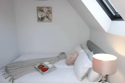 a white bed with a tray of food on it at Tulip Place in Chelmsford