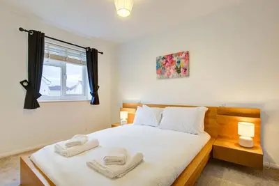 a bedroom with a bed with two towels on it at Comfortable 3 bed house in Chelmsford in Chelmsford