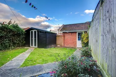 a house with a fence next to a yard at Comfortable 3 bed house in Chelmsford in Chelmsford