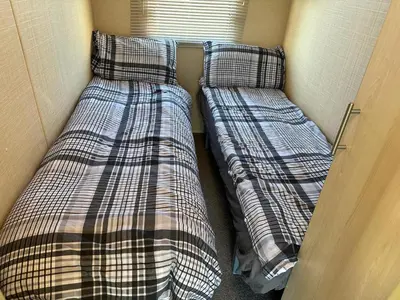 two beds in a small room next to a door at CaSa VistA - Holiday Home On The Beach in Clacton-on-Sea