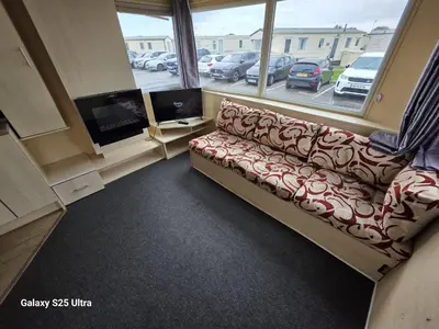 a living room with a couch and a large window at CaSa VistA - Holiday Home On The Beach in Clacton-on-Sea