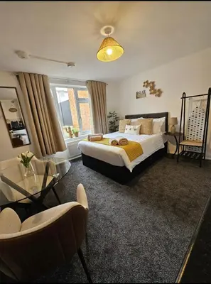 a bedroom with a bed and a couch and a chair at Stylish Studio Stevenage in Stevenage