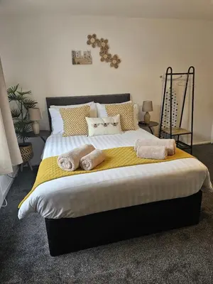 a bedroom with a large bed with towels on it at Stylish Studio Stevenage in Stevenage