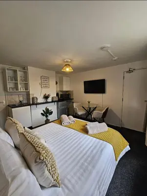 a bedroom with a large white bed with pillows on it at Stylish Studio Stevenage in Stevenage