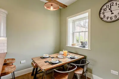 a dining room with a wooden table and a clock at 2 Bed in Blythburgh oc-t27735 in Blyford