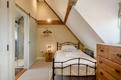 a attic bedroom with a bed and a bathroom at 2 Bed in Blythburgh oc-t27735 in Blyford