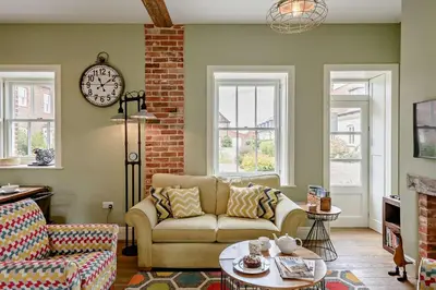a living room with a couch and a clock on the wall at 2 Bed in Blythburgh oc-t27735 in Blyford