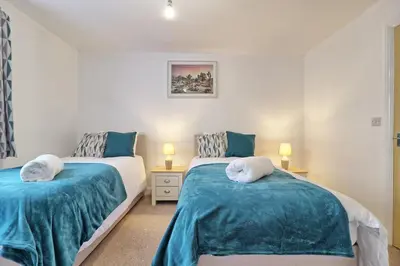 a bedroom with two beds with blue and white sheets at Hythe Hill Home in Colchester