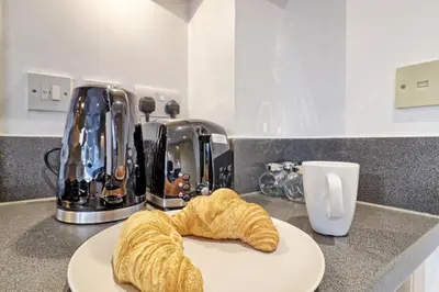 a plate of croissants on a counter with a coffee maker at Hythe Hill Home in Colchester
