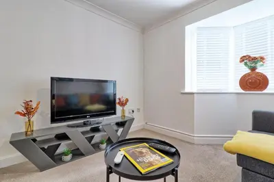 a living room with a flat screen tv on a table at Hythe Hill Home in Colchester