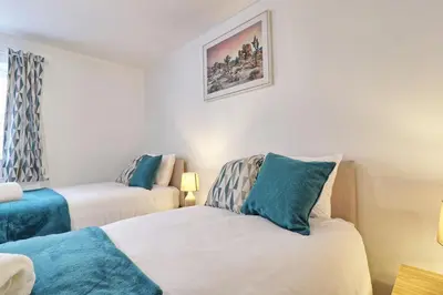a small room with two beds and a window at Hythe Hill Home in Colchester
