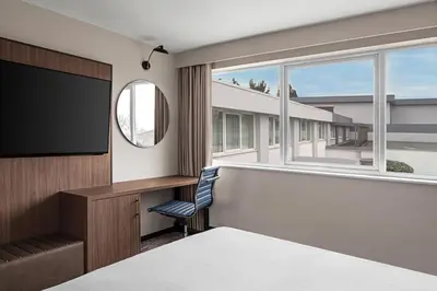 a hotel room with a flat screen tv and a window at Delta Hotels by Marriott Colchester in Colchester