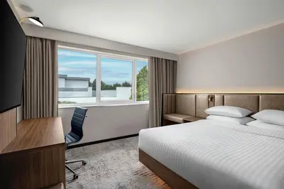 a hotel room with a bed and a desk and a window at Delta Hotels by Marriott Colchester in Colchester