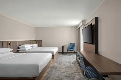 a hotel room with two beds and a flat screen tv at Delta Hotels by Marriott Colchester in Colchester