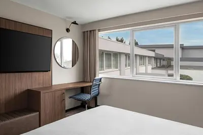 a hotel room with a flat screen tv and a window at Delta Hotels by Marriott Colchester in Colchester