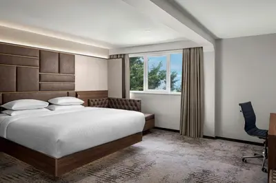a bedroom with a bed and a desk and a window at Delta Hotels by Marriott Colchester in Colchester