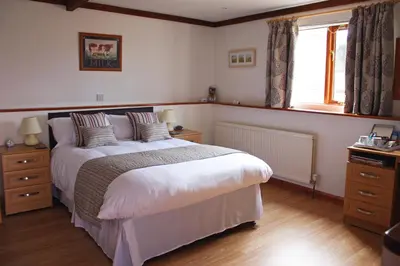a bedroom with a large bed and a window at Puttocks Farm in Great Dunmow