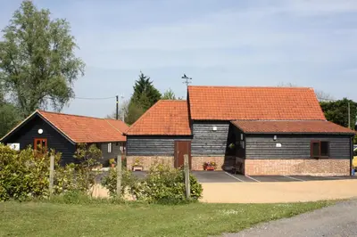 a group of three houses with orange roofs at Puttocks Farm in Great Dunmow