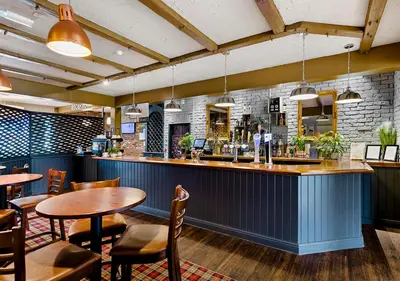 a bar in a restaurant with tables and chairs at Dragonfly Hotel Colchester in Colchester
