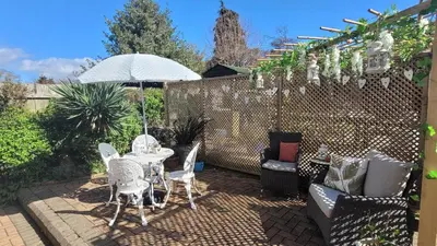a patio with a table and chairs and an umbrella at Mulberry Annexe in Felixstowe