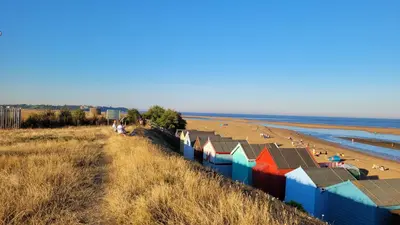 a view of a beach with colorful beach huts at Mulberry Annexe in Felixstowe