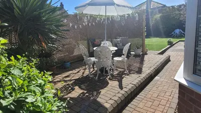 a patio with a table and chairs and an umbrella at Mulberry Annexe in Felixstowe
