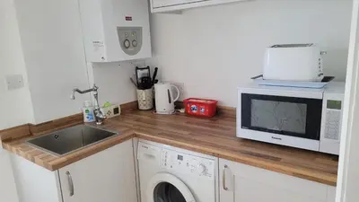 a kitchen with a sink and a microwave at Mulberry Annexe in Felixstowe