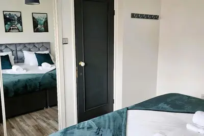 a bedroom with a bed and a black door at BSE Homes & Properties Ltd 4-Bedroom Home, Harlow , with Parking sleeps 6 in Great Parndon