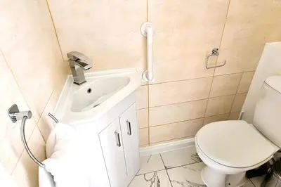 a bathroom with a white toilet and a sink at BSE Homes & Properties Ltd 4-Bedroom Home, Harlow , with Parking sleeps 6 in Great Parndon