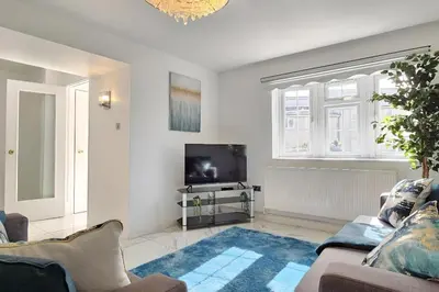 a living room with a couch and a tv at BSE Homes & Properties Ltd 4-Bedroom Home, Harlow , with Parking sleeps 6 in Great Parndon