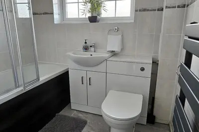 a white bathroom with a toilet and a sink at BSE Homes & Properties Ltd 4-Bedroom Home, Harlow , with Parking sleeps 6 in Great Parndon