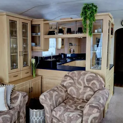 a living room with a chair and a kitchen at Sunshine Atlas Glamping Retreat in Jaywick Sands